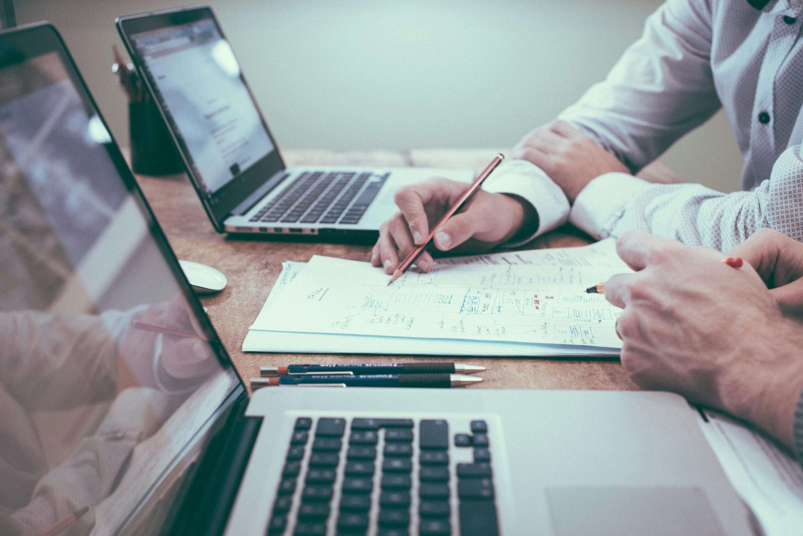 Real estate consultation meeting with professionals reviewing property plans and documents